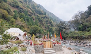 A riverside accommodation with a tent and a wooden fence.
