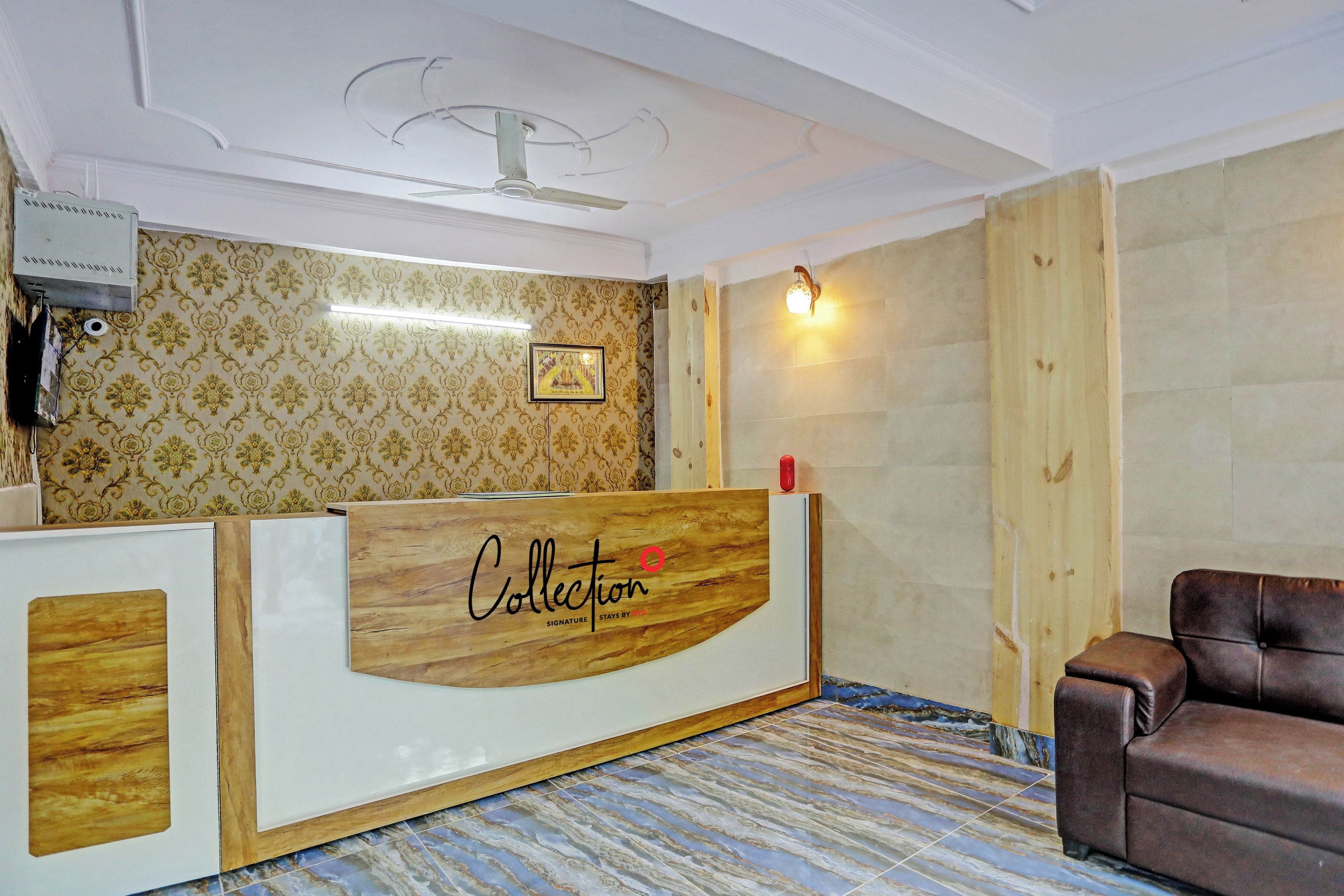 A reception area with a wooden reception desk, a framed picture on the wall, and a brown leather chair.