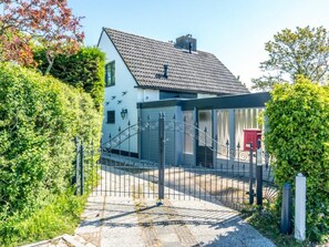 A house with a gated entrance, a sloped roof, and a pathway leading to the door. - Holiday Home With 3 Bedrooms (Burgh-Haamstede)