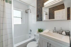 Un baño moderno con bañera, inodoro y lavamanos.