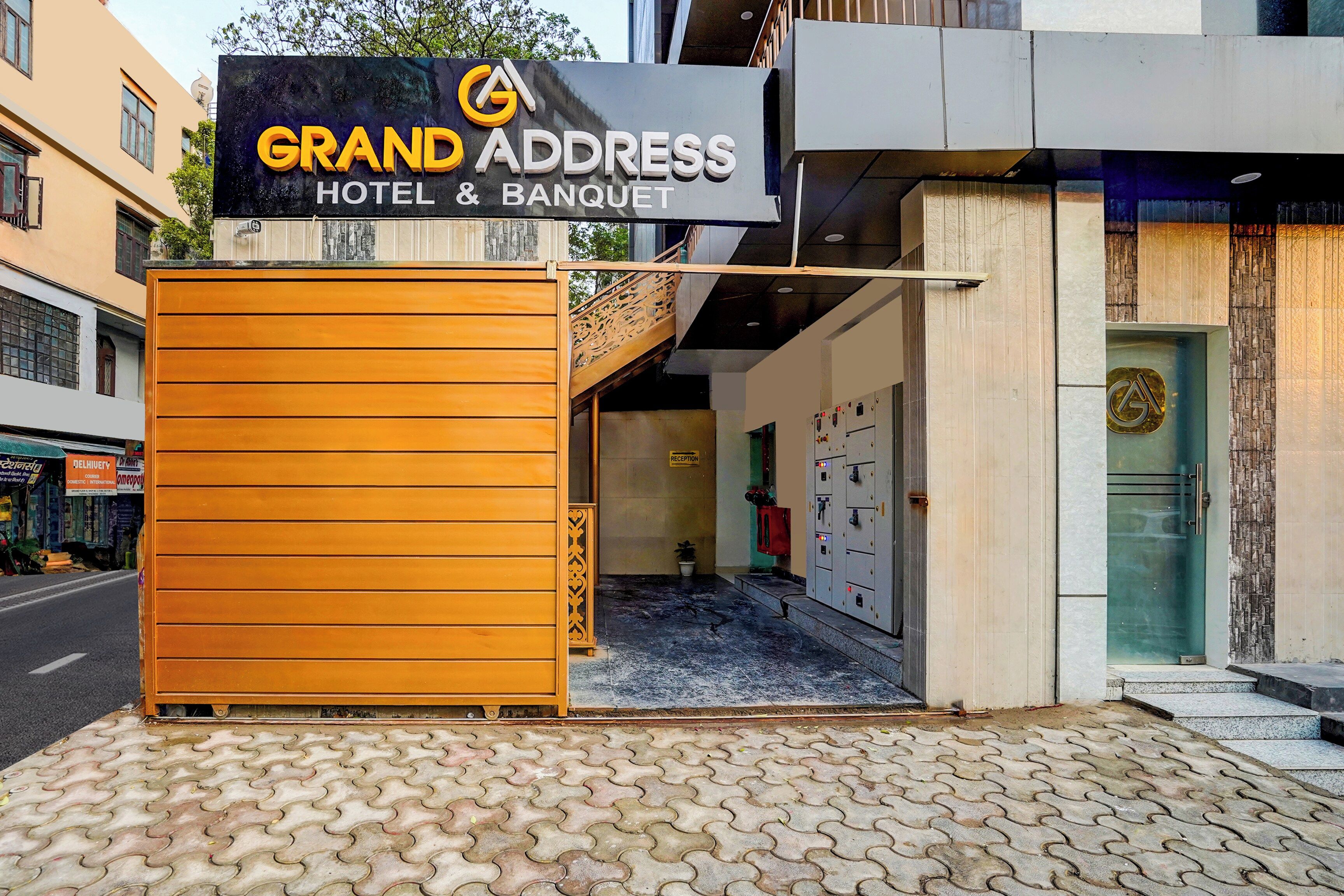 A hotel entrance with a sign reading 'Grand Address Hotel & Banquet.'