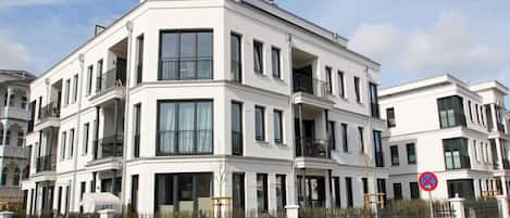 A multi-story residential building with balconies and large windows.