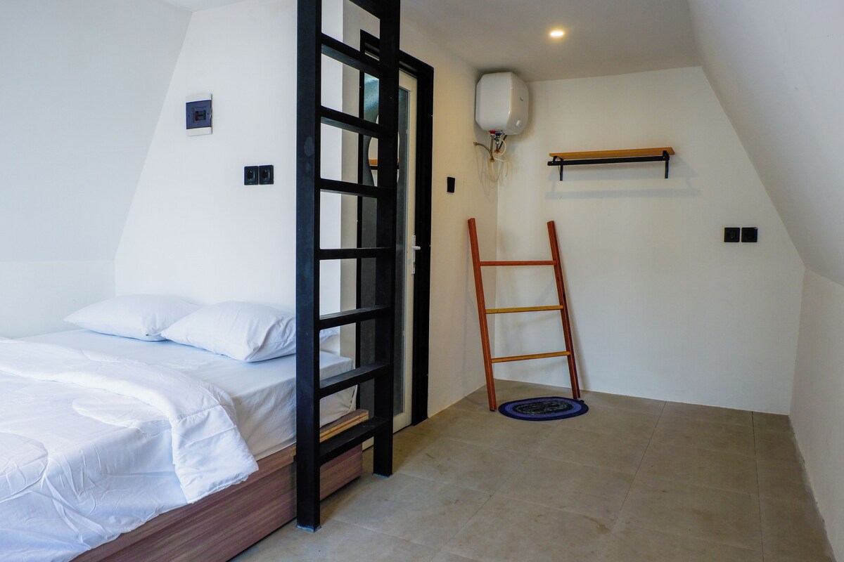 A bedroom with a bed, a ladder, a shelf, and a wall-mounted air conditioner.