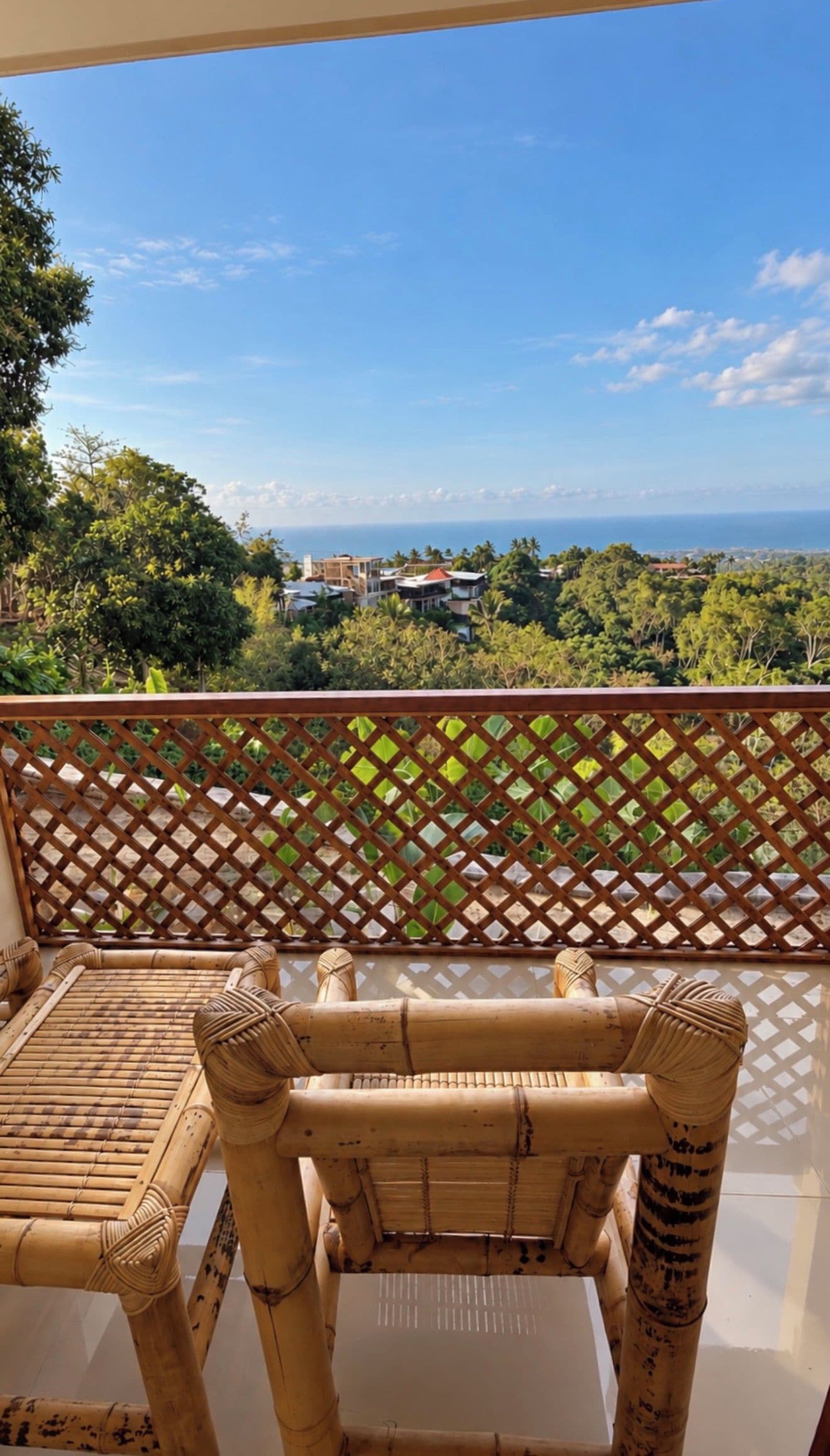 Un balcon avec vue sur l’océan et la végétation environnante.