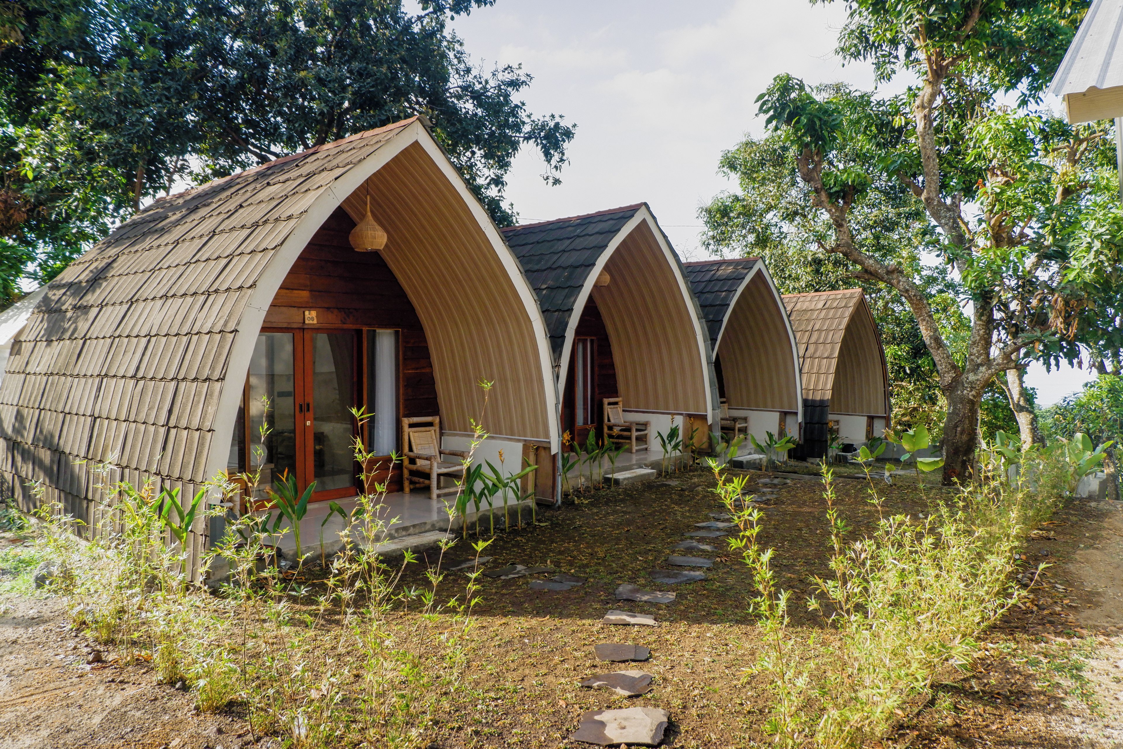 A row of A-frame cottages with a stone pathway leading to the entrance.