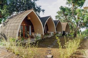 A row of A-frame cottages with a stone pathway leading to the entrance. - Windy Senaru (Kabupaten Lombok Utara)