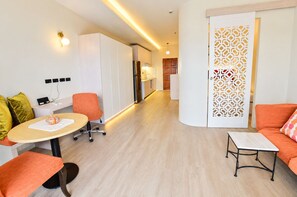 Un salon moderne avec une table à manger, des chaises orange et un canapé.