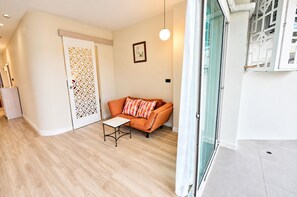 A modern living room with a sofa, a small table, and a decorative door. - Your Coastal Getaway Just Minutes From Jomtien Beach (Pattaya)