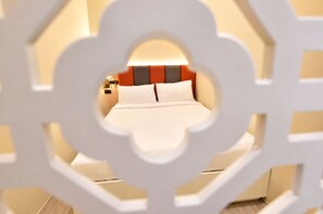 Une chambre d’hôtel avec un lit, des oreillers et une table de chevet.