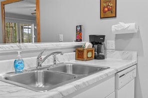 A kitchen with a double sink, a coffee maker, a bottle of dish soap, and a wooden crate labeled 'Country Market.' - Spring Creek Getaway (Branson)