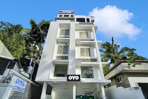 Un edificio de varios pisos con un letrero que dice 'Crystal Plaza' y 'OYO', indicando un hotel o establecimiento de hospedaje.