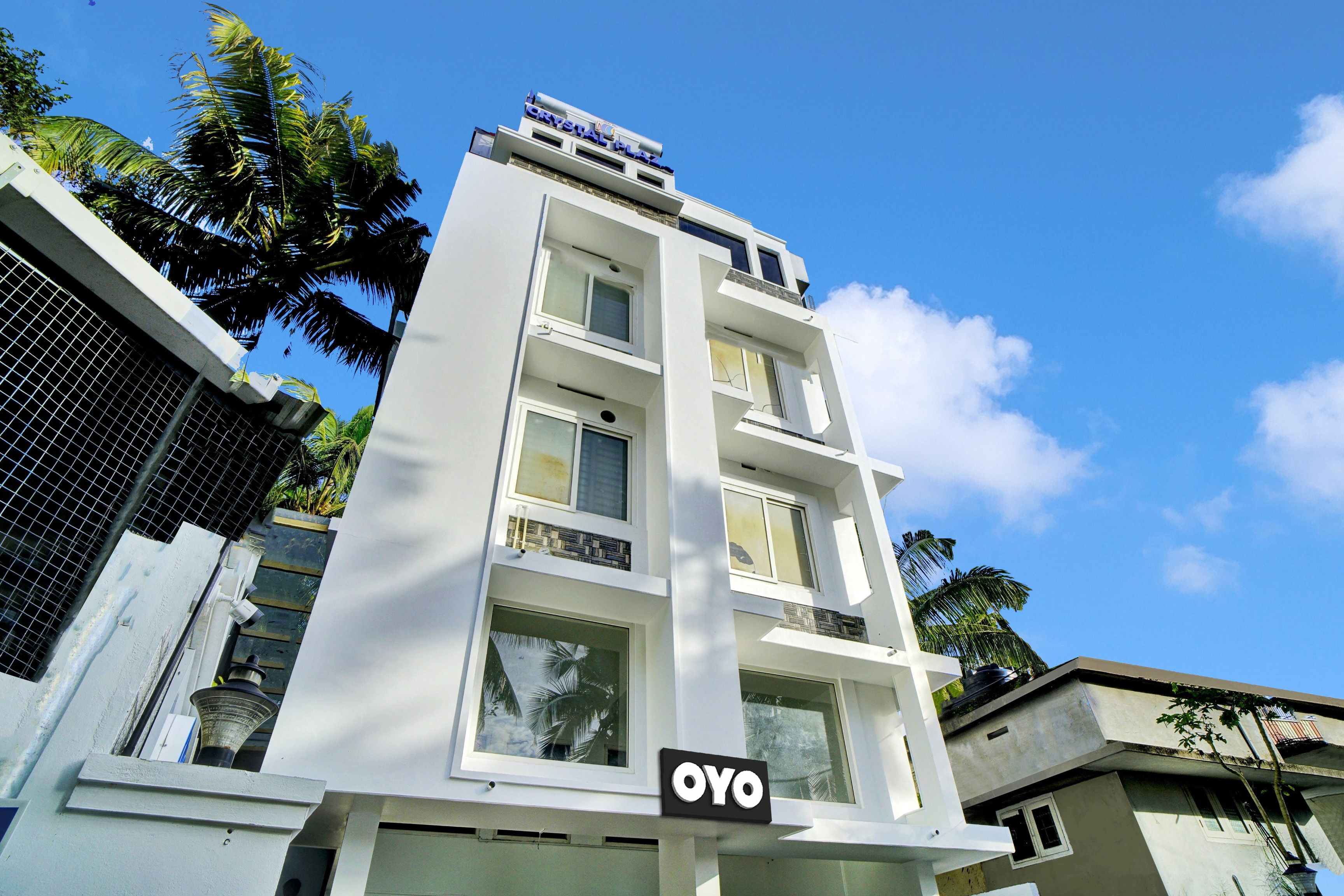 Un edificio de varios pisos con un letrero que dice 'Crystal Plaza' y 'OYO' hotel.