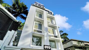 Un edificio de varios pisos con un letrero que dice 'Crystal Plaza' y 'OYO' hotel.