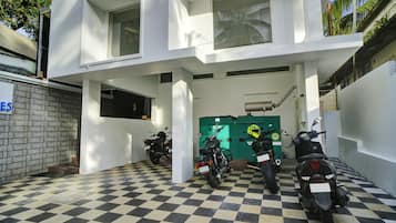 A building with a checkered floor, a green utility room, and parked motorcycles.