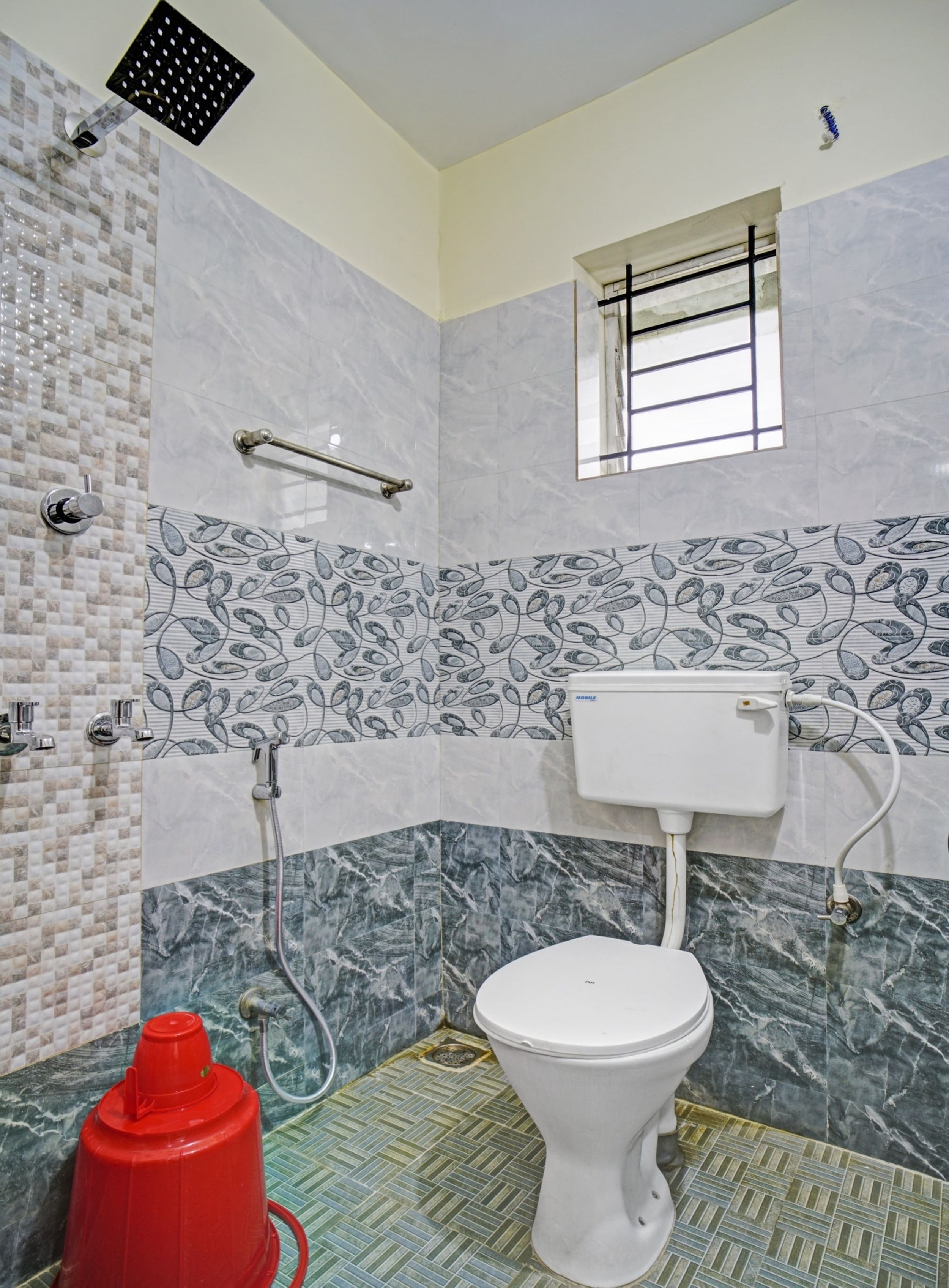A bathroom with a toilet, a shower, and a red fire hydrant.