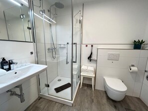 A modern bathroom with a glass-enclosed shower, a white sink, and a toilet. - Rosenhof To Wurth 12a (Busumer Deichhausen)