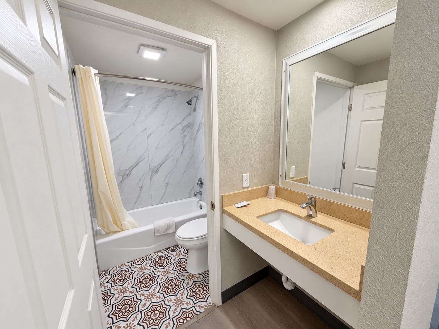 A bathroom with a bathtub, toilet, and sink.