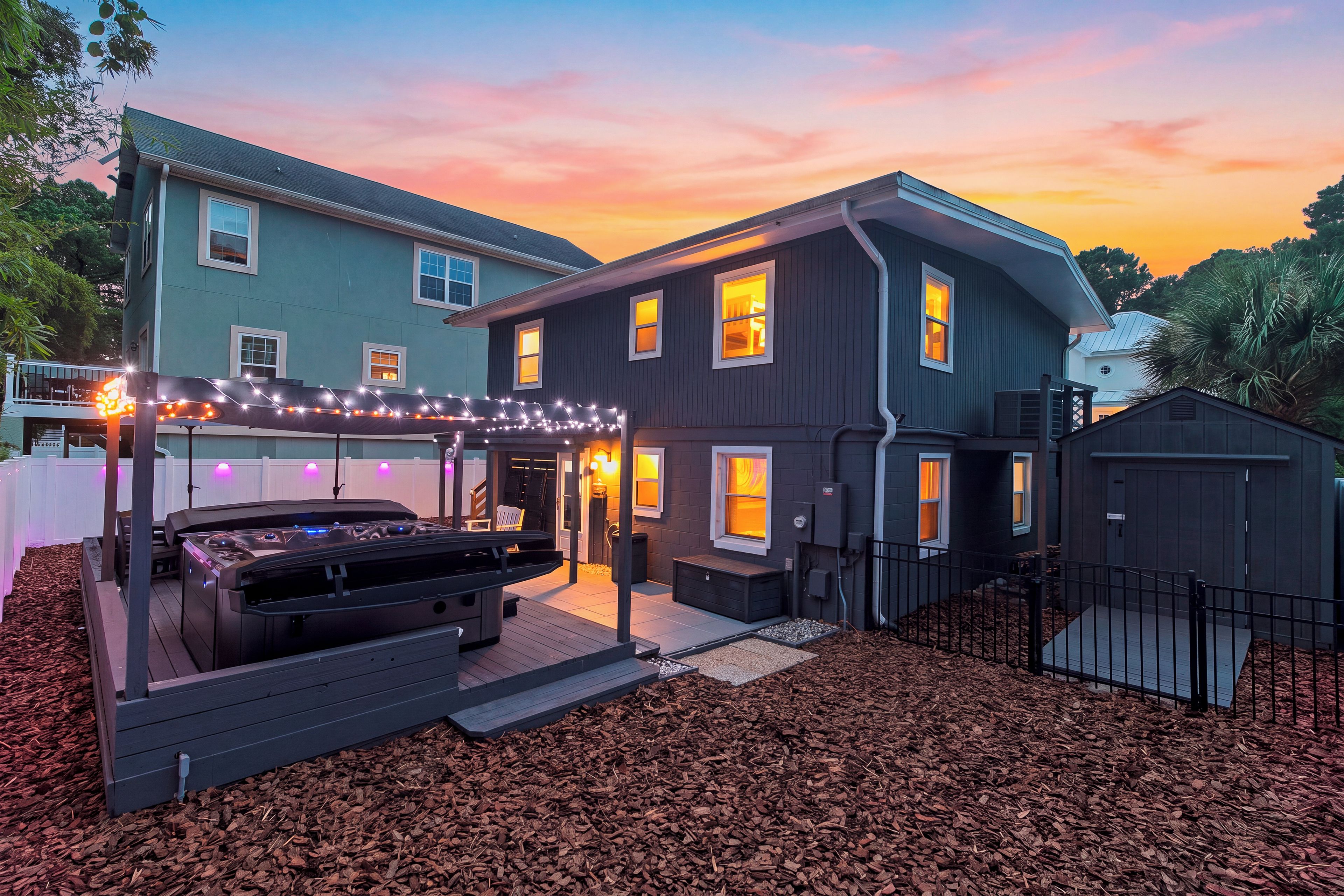 Twilight backyard relaxation with a glowing hot tub, cozy seating, and a private setting for memorable evenings.
