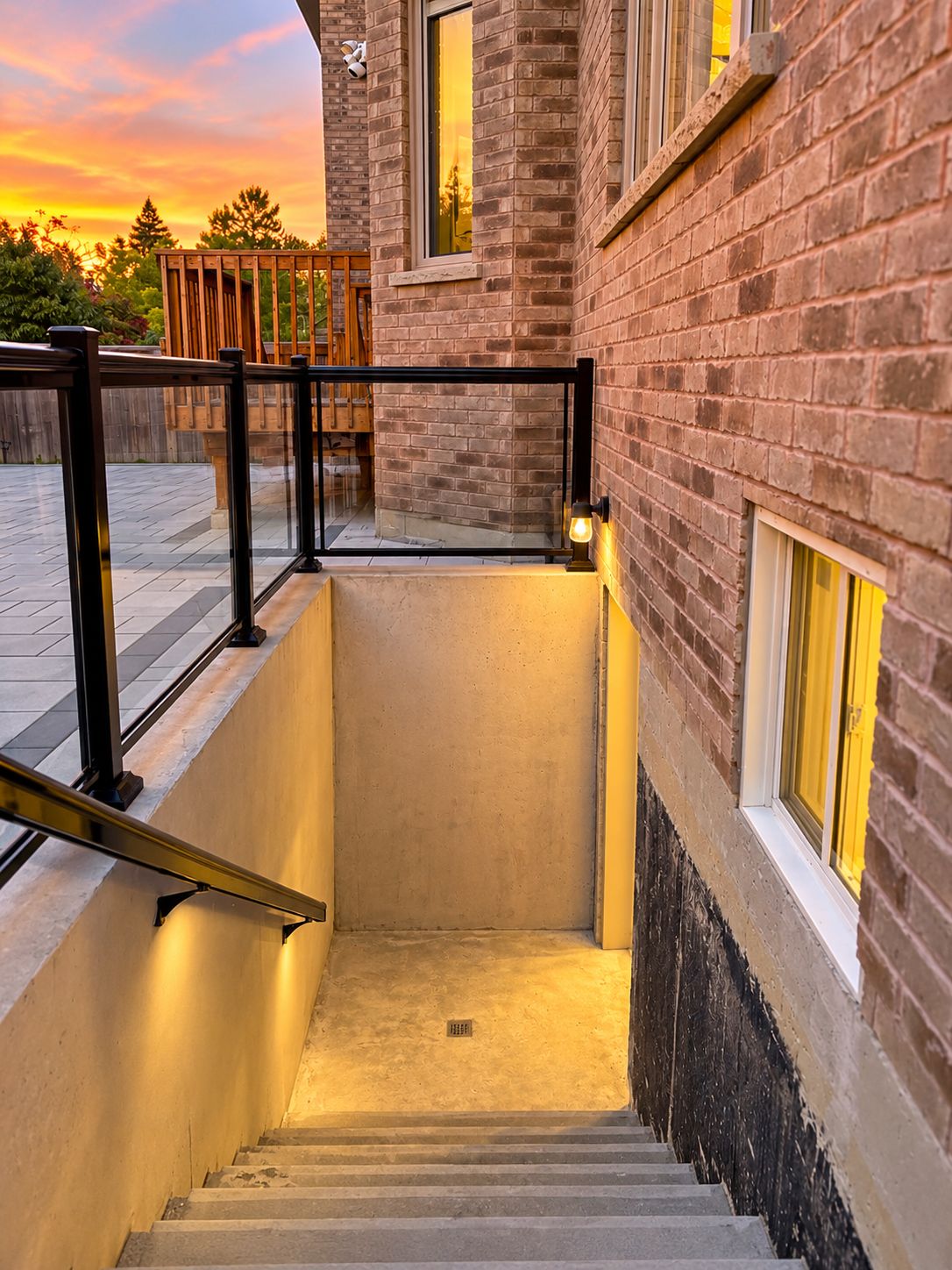 A staircase leading to a building with a brick exterior and a glass door at the top.