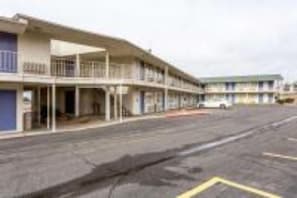 A multi-story motel with a flat facade, a covered front porch, and a parking lot in front. - Cozy Full Bed|Clean Room|Free Wifi (Albuquerque)