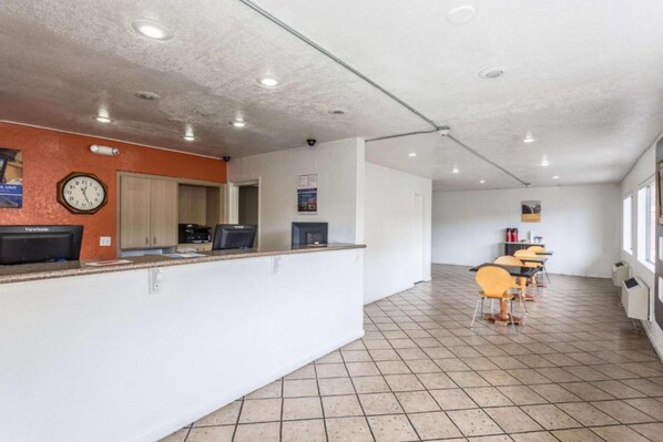 A reception area with a clock, a ViewSonic monitor, a counter, and a seating area with chairs and a table. - 1 FULL BED | MOBILITY ACCESS RI SHWR, NSMK (Albuquerque)