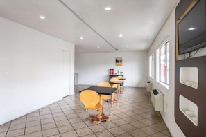A conference room with a white tiled floor, a white door, and a window with a view. - Cozy Full Bed Smoking Room (Albuquerque)