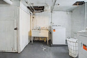 Habitació senzilla i funcional, amb un rentaplaats, una màquina de rentar i un safataire.