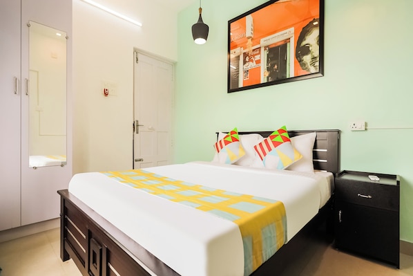 Quarto de hotel com cama, mesa de cabeceira e uma obra de arte na parede.
