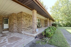 A brick building with a covered porch and a stone-paved entrance. - The Johnson Way: Cosby Home Near Gatlinburg (Cosby)