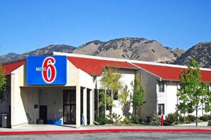A Motel 6 building with a red roof and a blue sign. - 2 Queen Beds | Non-Smoking (LEBEC)