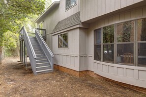 A house with a grey exterior, a wooden staircase, and a brick foundation. - Walk to the Stadium & Clemson: 3BR w/ Parking! (Clemson)