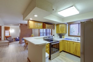 A kitchen with a central island, wooden cabinets, a built-in oven, and a window with a view. - Walk to the Stadium & Clemson: 3BR w/ Parking! (Clemson)
