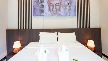 Une chambre d’hôtel avec un grand lit, deux lampes de chevet et une œuvre d’art accrochée au mur.