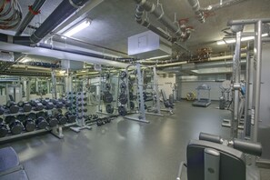 A gym with various exercise equipment, weight racks, and dumbbells. - Walk to Gaslamp & Petco Park! Dtwn Apt w/ Balcony (San Diego)