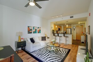 A modern living room with a sofa, coffee table, and artwork on the wall. - Walk to Gaslamp & Petco Park! Dtwn Apt w/ Balcony (San Diego)