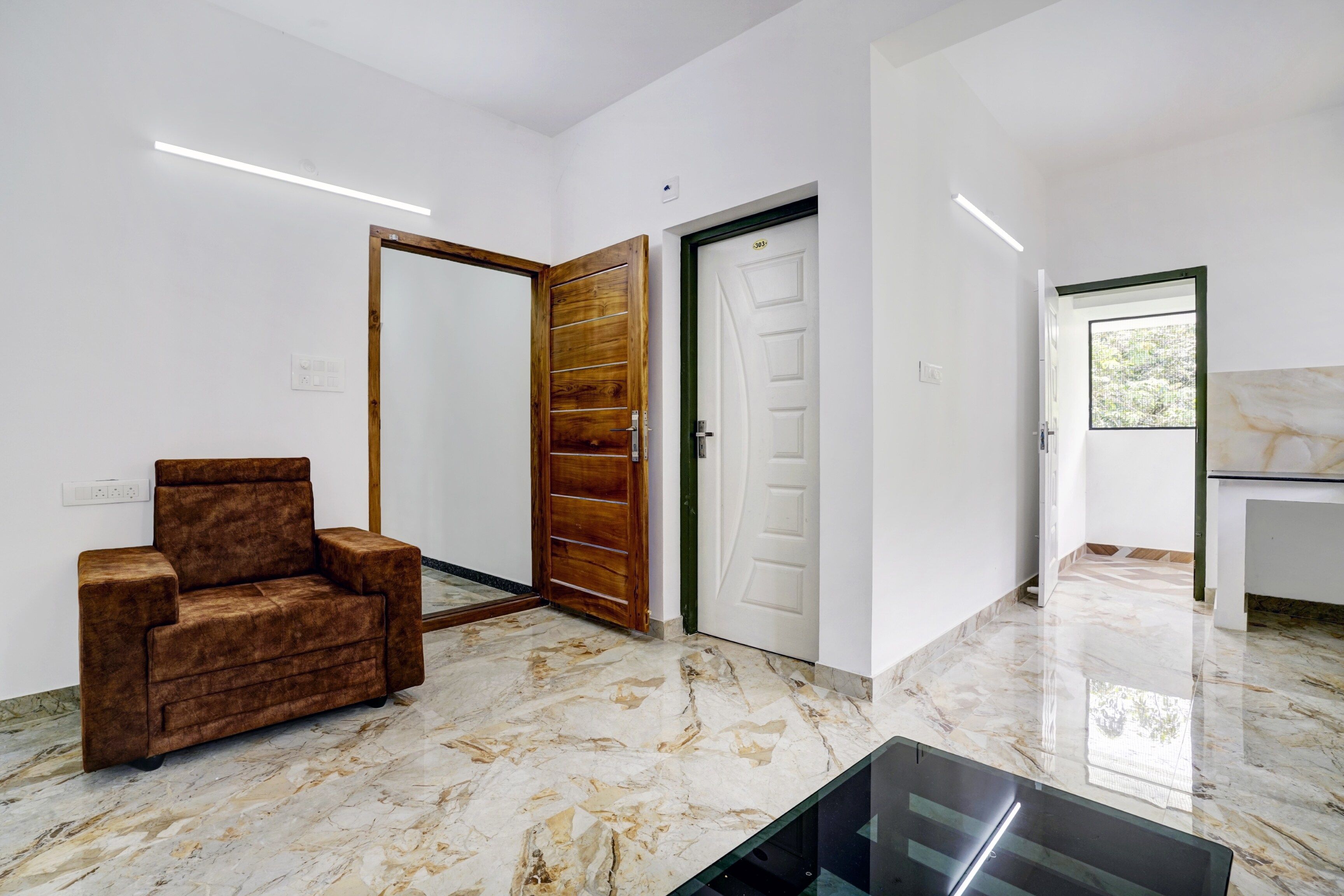 A modern interior with a marble floor, a brown sofa, and a wooden door.