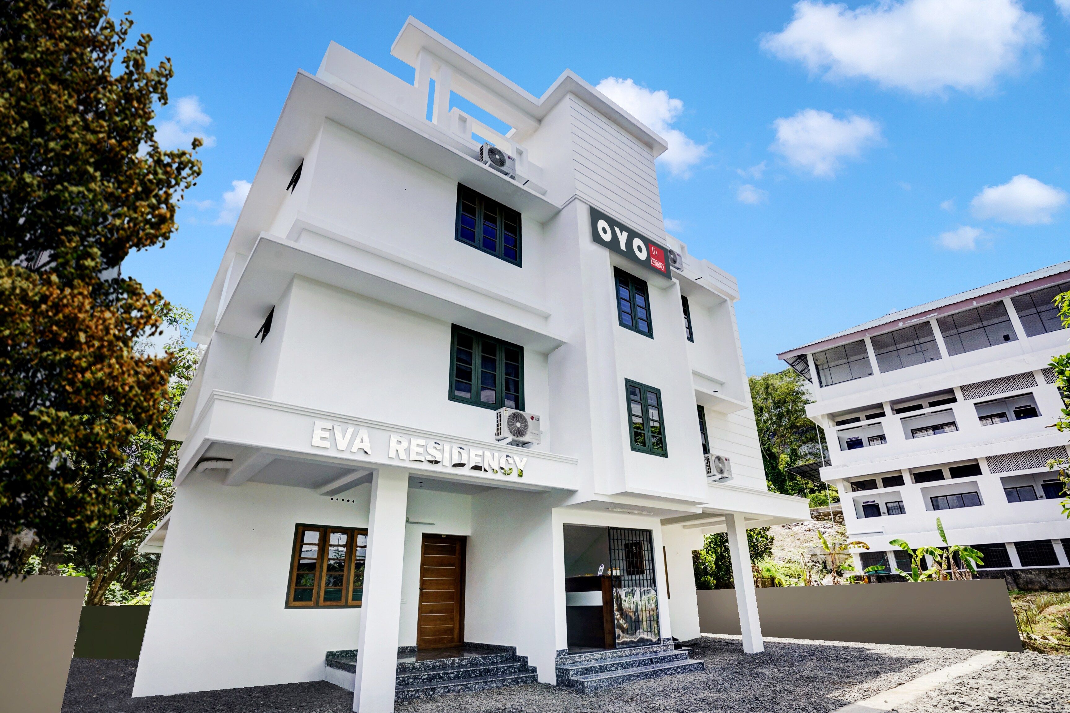 A multi-story building with a sign reading 'EVA RESIDENCY' and 'OYO'.