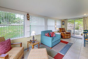 Ein Wohnzimmer mit einer Couch, Sesseln, einem kleinen Tisch und einer Lampe.