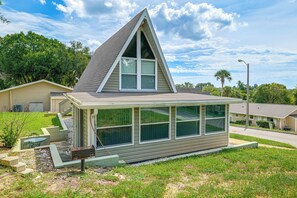 A small, single-story house with a gable roof and large windows. - 'Livin' on Sunshine' Lake Louisa Escape! (Clermont)