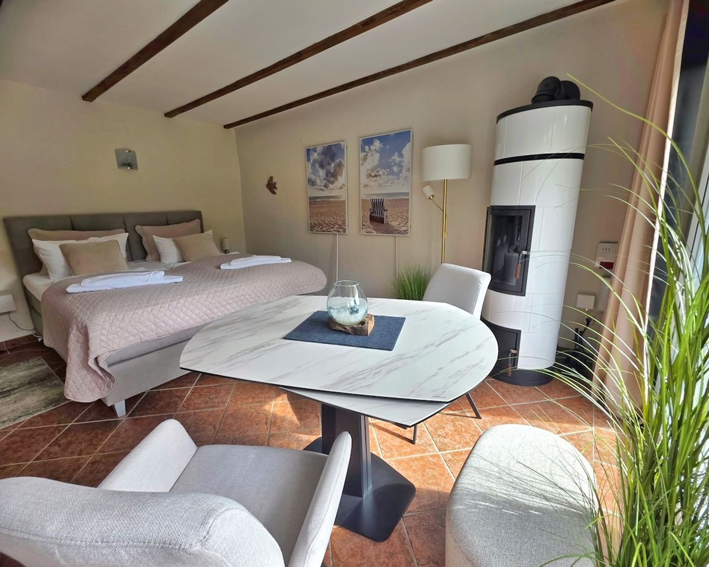 Une chambre d’hôtel comprenant un lit, une table à manger, des chaises, un aquarium, une lampe et une cheminée.