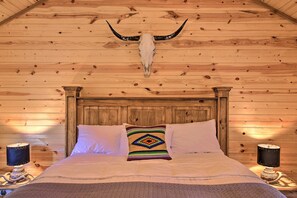 A wooden cabin-style bedroom with a bed, pillows, and a decorative skull on the ceiling. - Fredericksburg House & Cabin 10 Mi to Main St (Fredericksburg)
