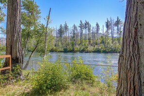 A river with a wooden fence in the foreground and trees in the background. - McKenzie River Home w/ Waterfront Fire Pit (Vida)