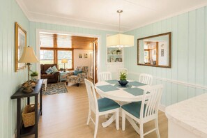 A dining area with a round table, white chairs, and a chandelier. - 'Paradise Found' on Lake Louisa: Swim + Fish! (Clermont)