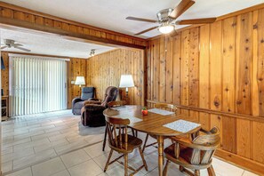 A dining area with a wooden table, chairs, and a ceiling fan. - Parrot Head Paradise: Lake Access & Pickleball (Clermont)