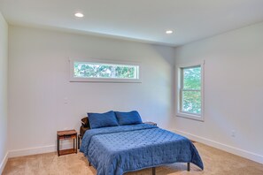 A bedroom with a bed, two windows, and a carpeted floor. - Large Deck w/ Views! Brand New Three Rivers Home (Three Rivers)