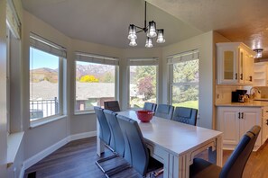 A kitchen with a dining table, chairs, and a view of mountains. - Extended Mtn-View Stay w/ Hot Tub Near Skiing (Mountain Green)