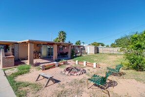 Propiedad residencial con patio, mobiliario exterior y un pozo de fuego.