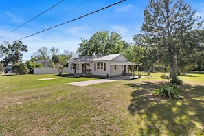 A single-story house with a front porch, a small yard, and a tree in front. - Cute, Cozy & Near Downtown! Updated Home w/ Porch (Live Oak)