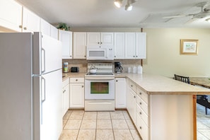 A kitchen with white cabinets, a refrigerator, a microwave, an oven, and a coffee maker. - License to Chill: Lake Access, 14 Mi to Disney (Clermont)
