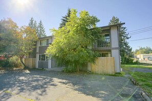 Un bâtiment à deux étages, doté d’un design moderne, avec une porte de garage bien visible et un arbre devant.